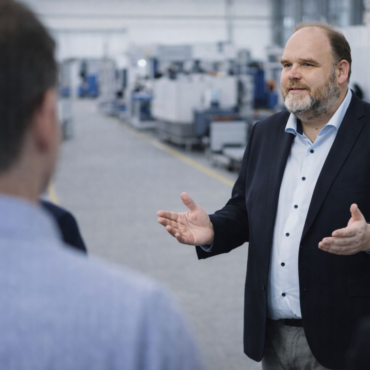 Markus Krüger im persönlichen Gespräch in einer Produktionshalle